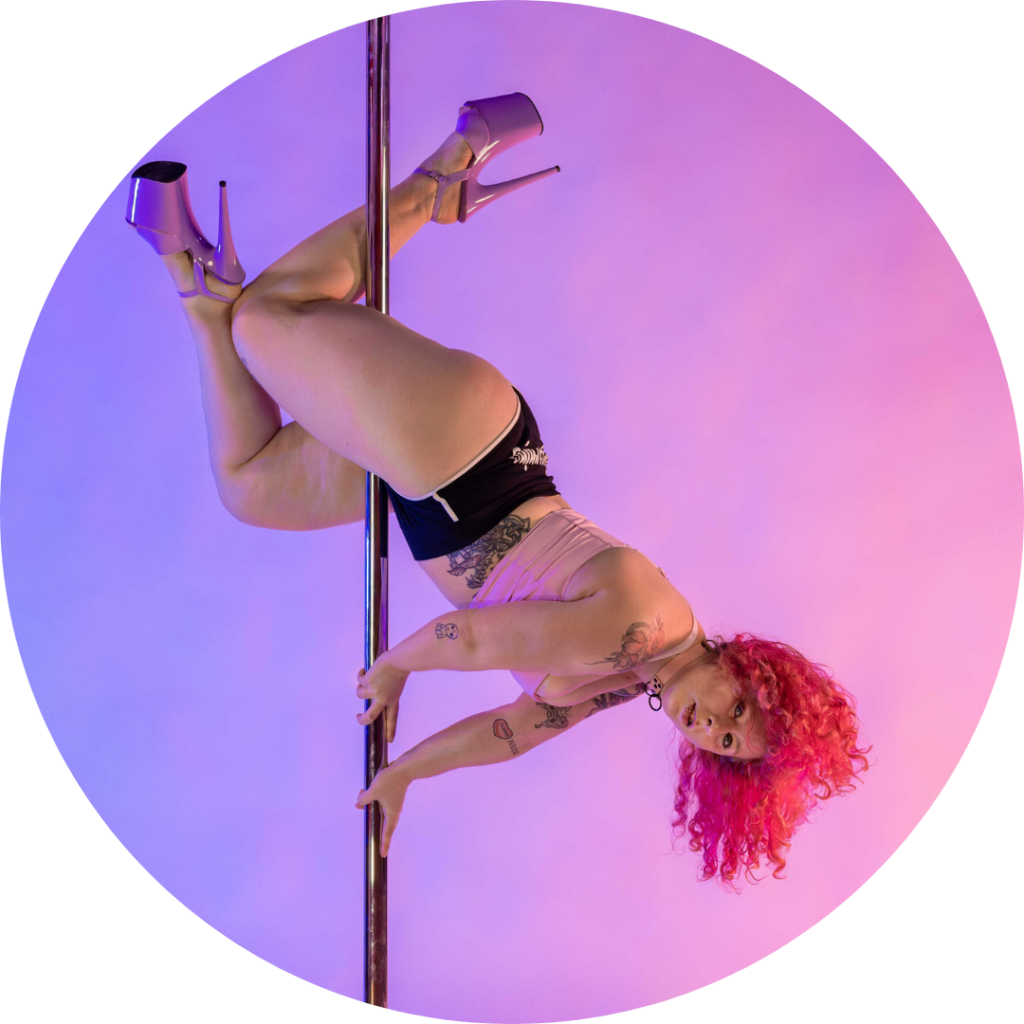 A photo of Clara doing a single-leg dive on the pole.