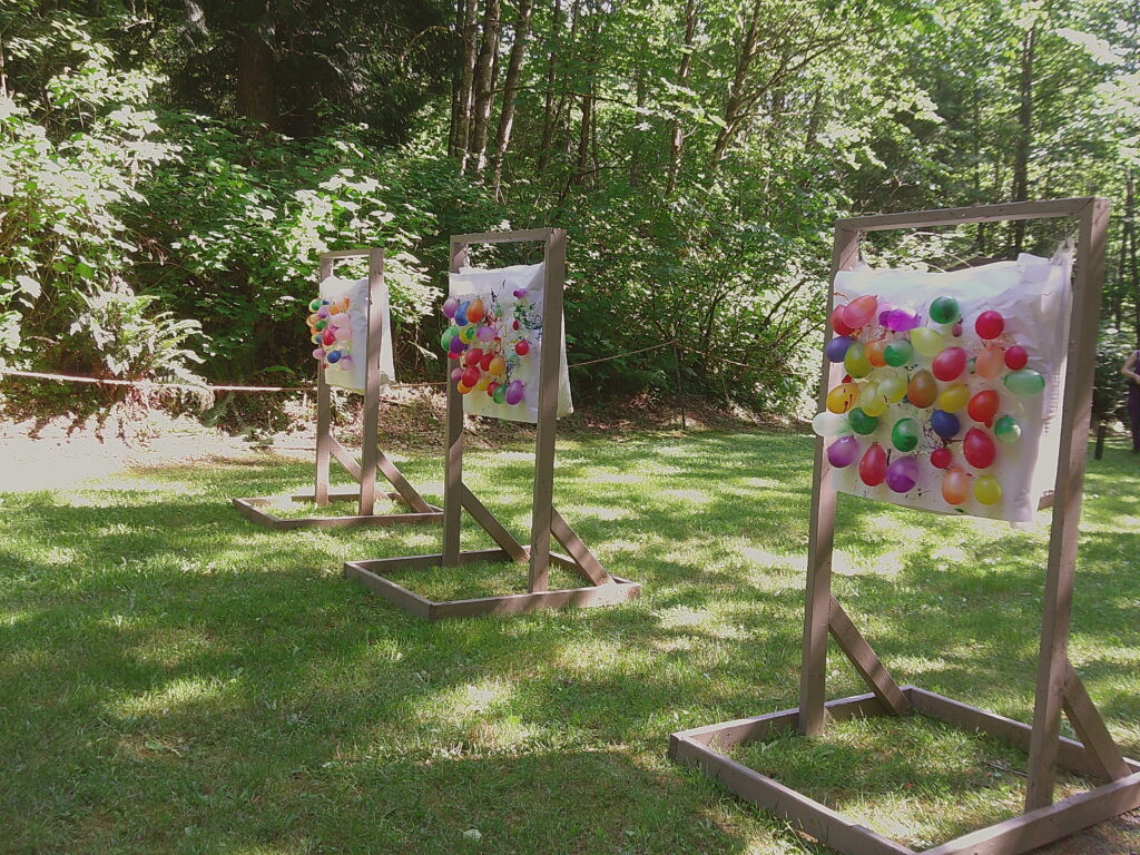 An archery range set up with balloon targets outdoors.