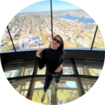 Fatma smiling against a city backdrop.