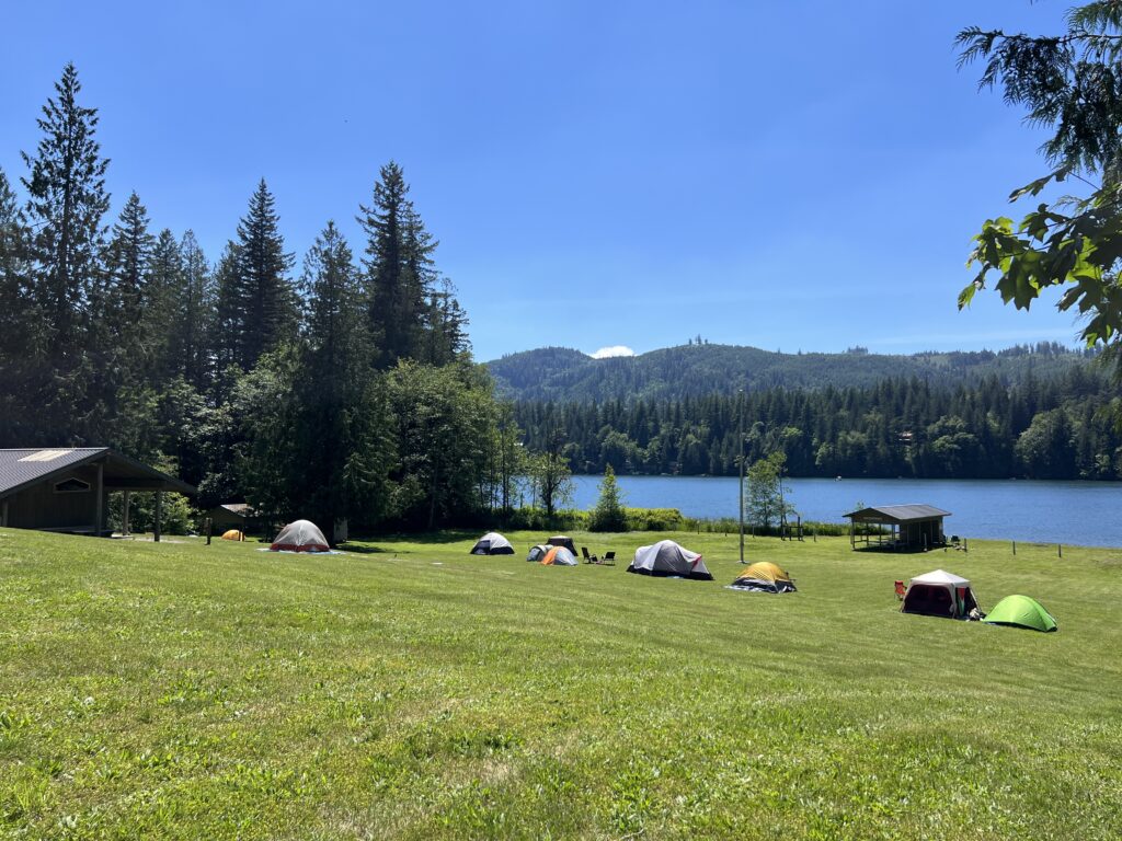 Tent camping site on the lake side in the sun.