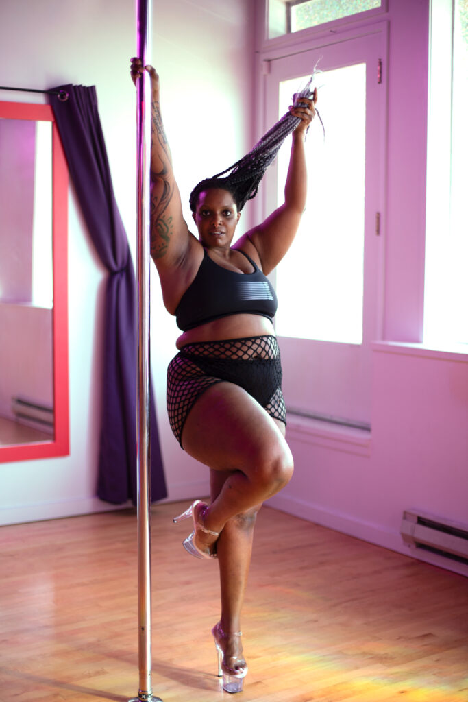 A pole dancer in heels at a well lit studio
