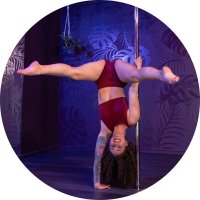 A picture of Kenni doing a pole handstand glider against a purple background.